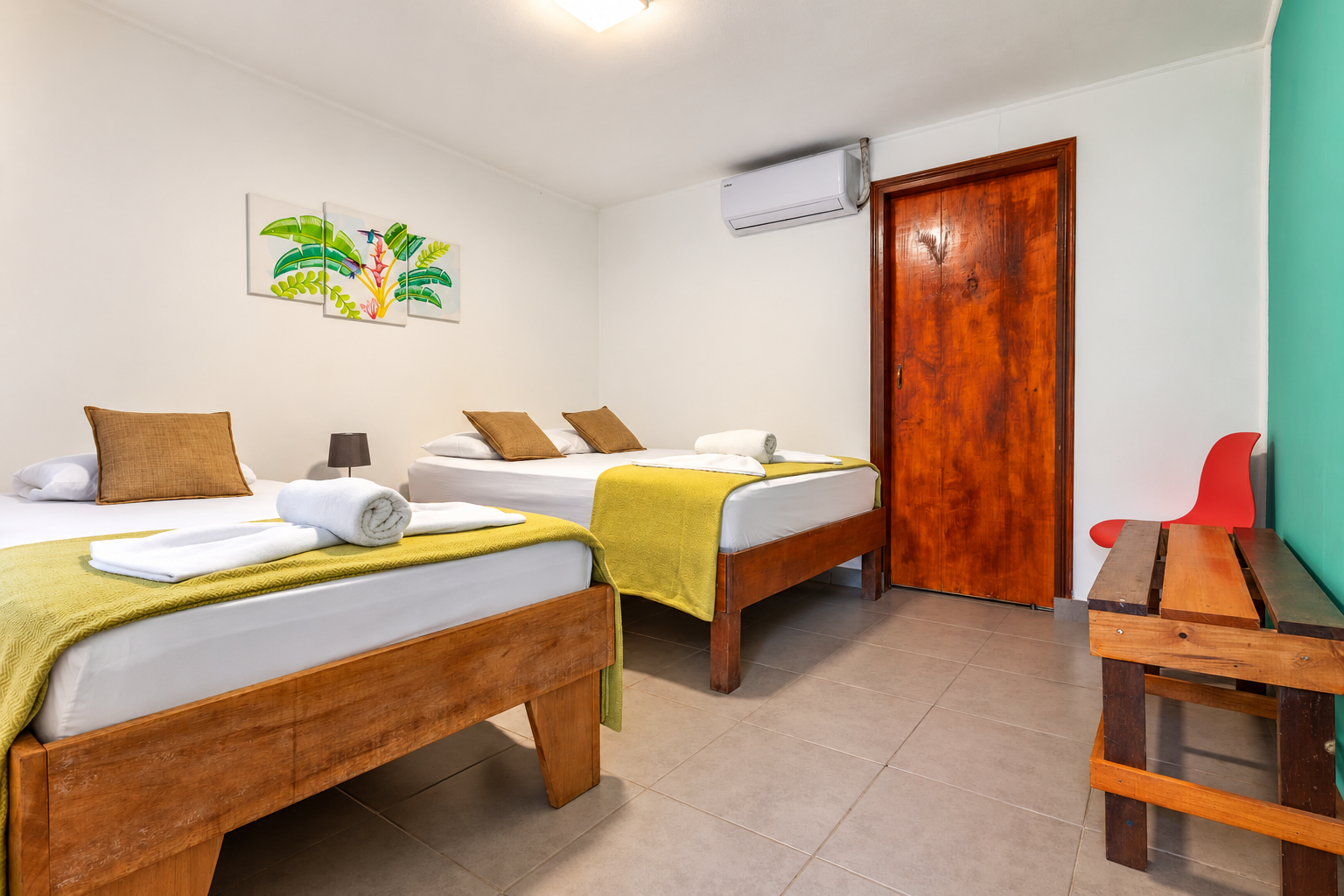 Habitación de La Casona con camas de madera y aire acondicionado